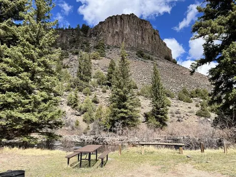 500-foot-high rock formation above river, forest and rocky terrain