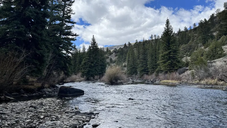 River, rocky shoreline surrounded by hills and trees