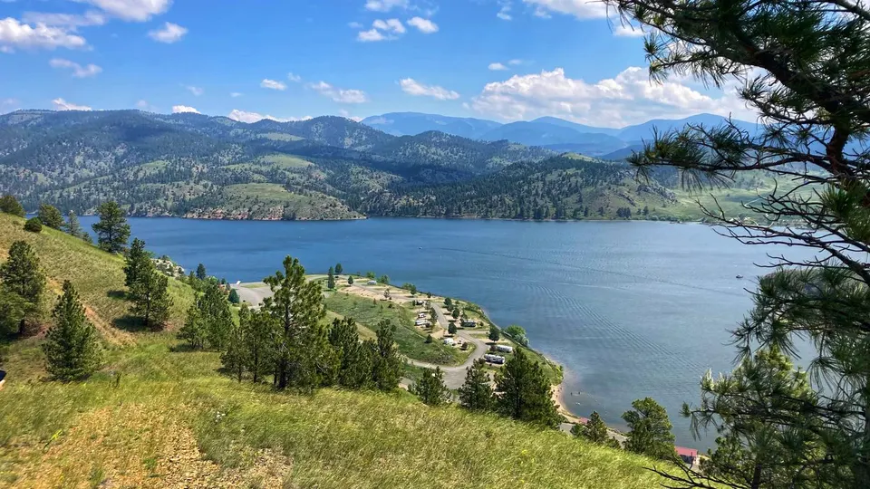 BLM White Sandy Campground overview. Beach area in the foreground. Site located on Hauser Lake. Campsites located along water's edge.