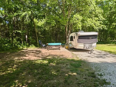 A small white camper sits in a campsite at Erbie Campground.