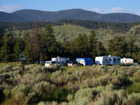 Trucks and trailers in a group campsite.