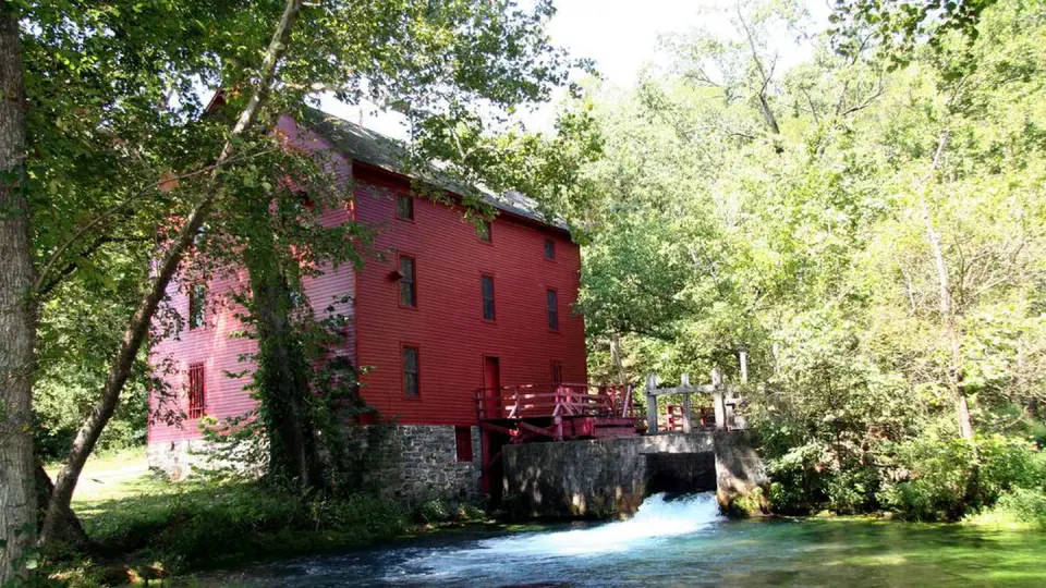 Bright red Alley Mill under the summer sun and shade trees