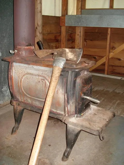 Metal Stove with pulaski leaning against it