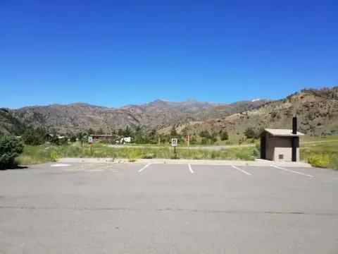 Rex Hale Campground Parking Lot with outhouse, mountains are in background
