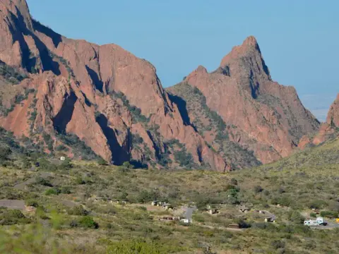 Chisos Basic Campground Area from a distance surrounded by mountain peaks