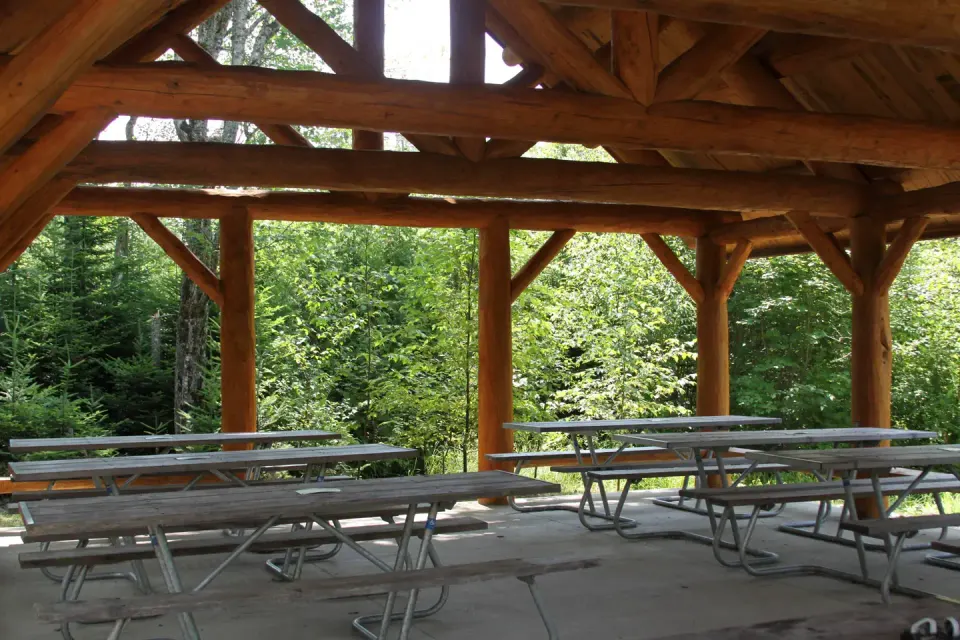 Interior view of log cabin style picnic pavilion with accessible picnic tables.