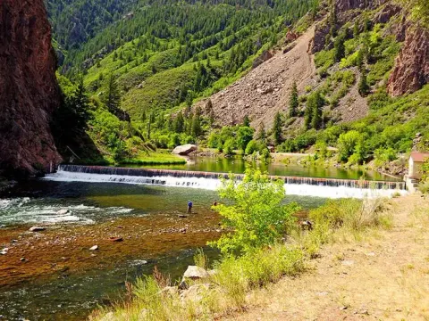 A view of historic East Portal with a fisherman dwarfed by canyon walls
