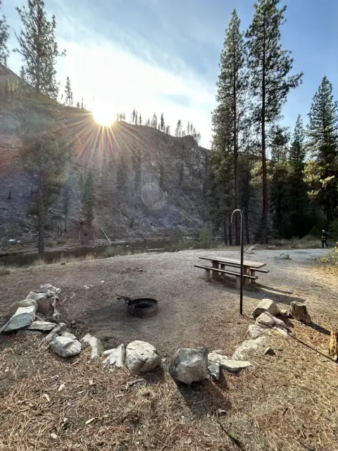 Campsite with picnic table, fire ring, and lantern hook.