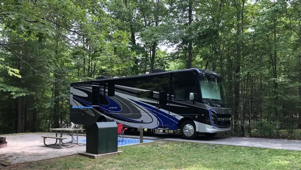 Bandy Creek Campground with motor home in a campsite in Loop D. Grass and green trees plenty of shade.
