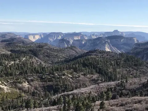 A panoramic view from Lava Point Lookout showing peaks and mesas.