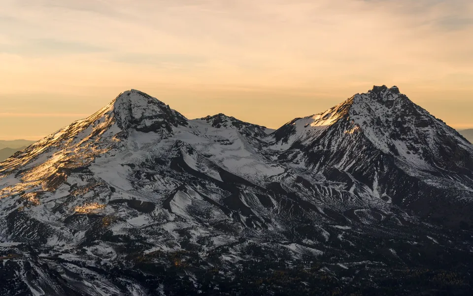 A breathtaking view of snowcapped mountains during sunset near Bend, Oregon, capturing the serene natural beauty.