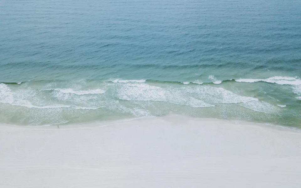 A serene aerial image showcasing the tranquil beaches and clear waters of Orange Beach, Alabama.