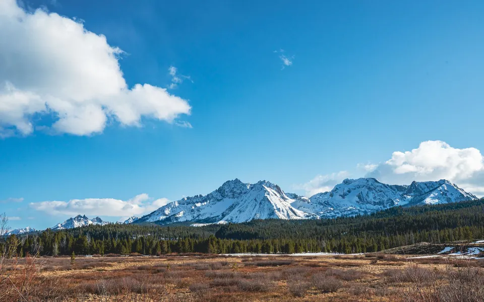 Breathtaking view of the snow-capped Sawtooth Mountains in Stanley, Idaho under a clear blue sky.